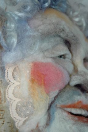 Rose Alba - Hand needle-felted wool sculpture of a female face – laughing, blue haired. Mounted on reclaimed birch bark. artist/photo: Rosemarie Péloquin.