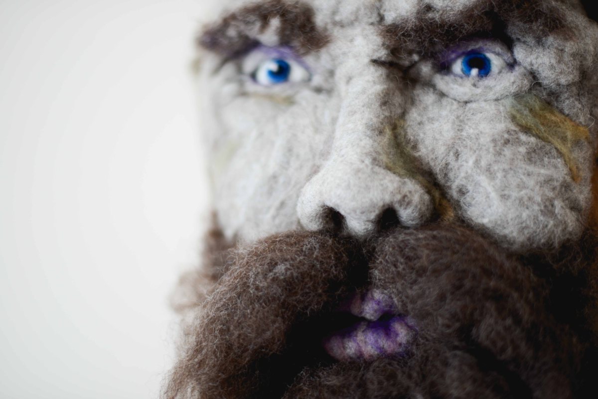 Ti-Jean - Hand needle-felted wool sculpture of a male face – dark brown hair, moustache and beard. Mounted on reclaimed birch bark. Artist: Rosemarie Péloquin; photo: Emily Christie.