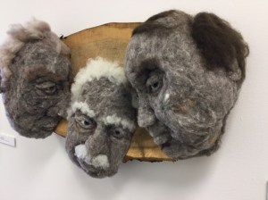 The Meeting 2016 - Hand-needlefelted wool sculpture - three male faces leaning together and looking out towards someone; mounted on cottonwood. artist: Rosemarie Péloquin. photo: Anne Fallis