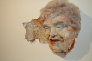 Mirth - Hand needle-felted wool sculpture of a female face – kind, chuckling. Mounted on reclaimed birch bark. artist: Rosemarie Péloquin; photo: Emily Christie.