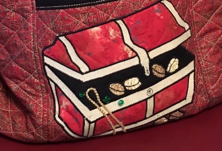 A cropped photo of a quilted treasure chest bag.