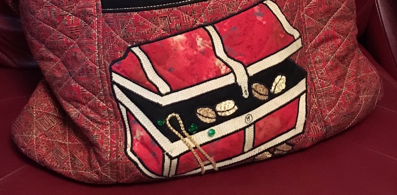 A cropped photo of a quilted treasure chest bag.